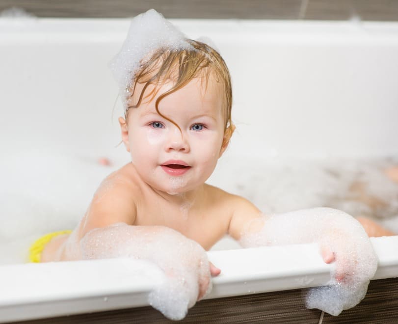 bebé con espuma en la bañera